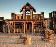 an old western town with a horse and wagon in the foreground, two wooden buildings on either side