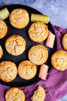 several muffins on a black plate with celery sticks and an apple