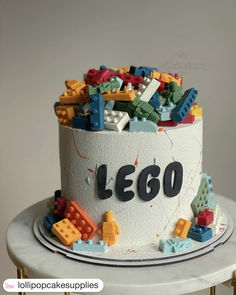 a birthday cake with lego blocks on top and the word lego spelled out in black