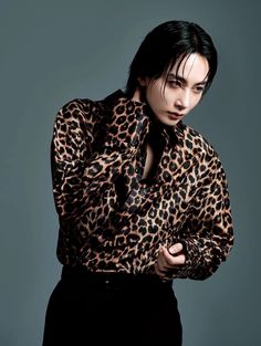 a woman with black hair wearing a leopard print shirt