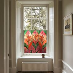 an image of a window with flowers painted on the glass and in front of it is a potted plant