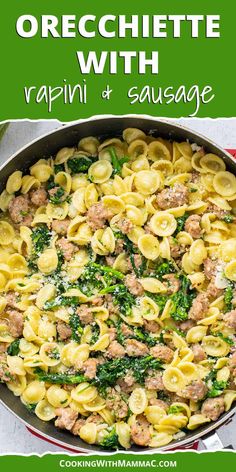 a skillet filled with pasta, sausage and spinach on top of a table