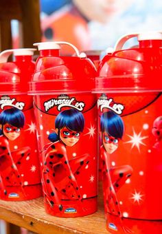 red plastic cups with cartoon characters on them are sitting on a shelf in a store