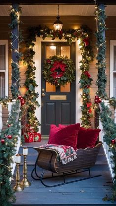 the front porch is decorated for christmas with wreaths, garland and lights on it