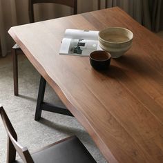 a wooden table with a magazine and bowl on it