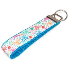 a keychain with a flower design on it and a metal hook in the middle