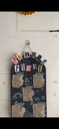 a chalk board with some stickers on it hanging from the side of a wall