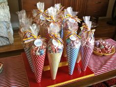 candy cones are wrapped in cellophane and tied with bows on a red tray