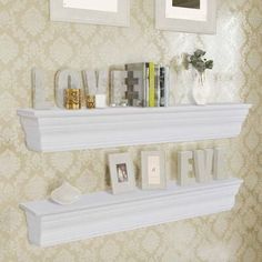 two white shelves with pictures on them in a room