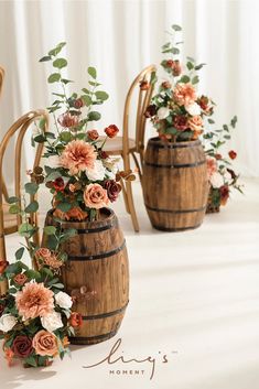 three wooden vases with flowers and greenery on them