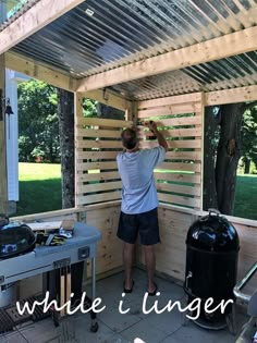 a man standing in front of a bbq on top of a wooden deck next to a grill