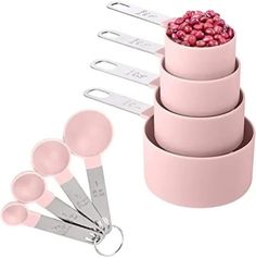 pink measuring cups and spoons are stacked on top of each other