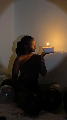 a woman sitting on the floor with a cake in her hand