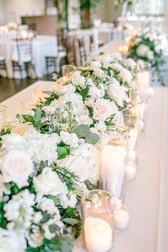 a long table with white flowers and candles on the top is set up for a formal function