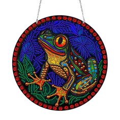 a brightly colored frog is hanging on a chain