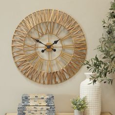 a clock that is on the wall next to a vase and some books in front of it