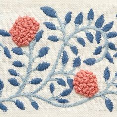 an embroidered piece with blue and pink flowers on it