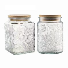 two glass jars with wooden lids are shown