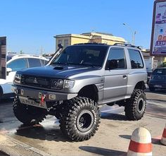 a silver truck parked next to other cars in a parking lot