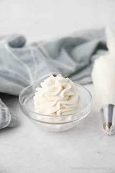 a glass bowl filled with whipped cream on top of a table