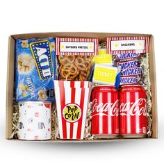 a box filled with popcorn, sodas and other snacks on top of a table