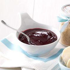 two bowls filled with jam next to some bread