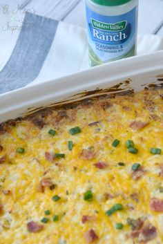 a casserole dish with ham and cheese on it next to a bottle of ranch seasoning