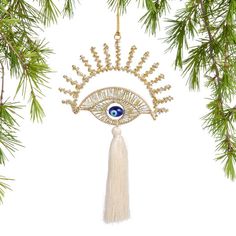 a christmas ornament with an evil eye and tassels hanging from it