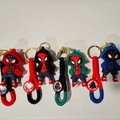 four spider - man keychains are lined up in a row