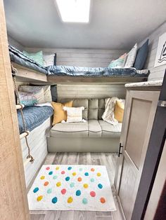 the inside of a small rv with bunk beds and couches in it's corner