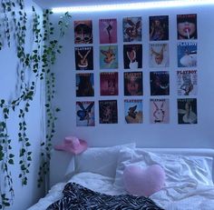 a bedroom with posters on the wall and a bed in front of it that has pink pillows