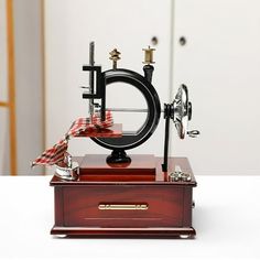 an old fashioned sewing machine on display in a room with white walls and flooring