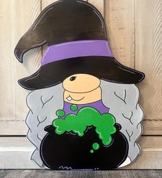 a wooden sign with a witch holding a caulder and green broccoli