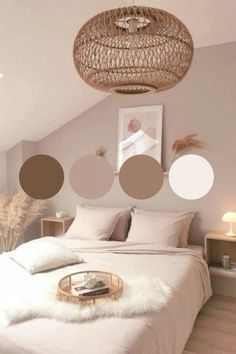 a bedroom with white bedding and neutral colored circles hanging from the ceiling above it