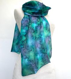 Hand painted pure silk scarf with hand-rolled edges.  In a light weight silk. This is showing the silk scarf in a soft turquoise blue with emerald green and splashes of darker blue in a water-effect finish.  The water-effect finish allows the colours to softly merge and blend and creates a rippled-water like effect. It is 12" wide (33cm) by a generous 72" long (180cm) in a floaty silk which can be worn in any number of ways. The silk is hand painted by artisans in Northern India who are members Rippled Water, Pure Silk Scarf, Bleu Turquoise, Silk Painting, Silk Scarves, Pure Silk, Favorite Things Gift, Silk Scarf, Emerald Green