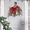 a white door decorated with red and green poinsettis, bells and greenery