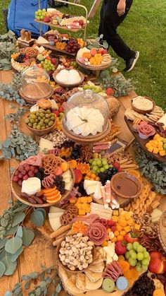 a long table covered with lots of different types of cheeses and fruit on it