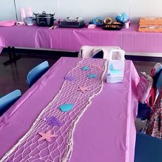 the table is covered with purple cloths and decorations