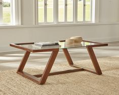 a coffee table with a glass top and wooden legs