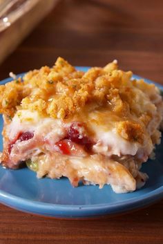 a blue plate topped with lasagna covered in cheese and toppings on top of a wooden table