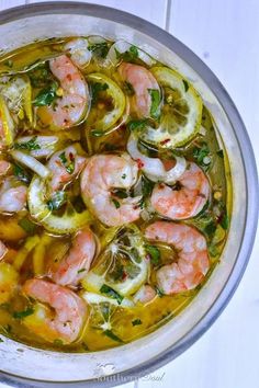 a bowl filled with shrimp and lemon slices