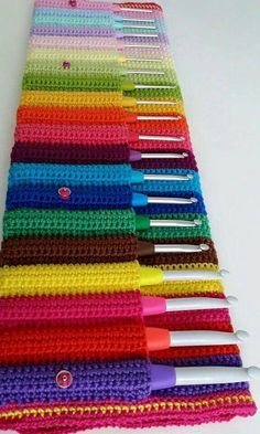 the crocheted table runner is lined up with many different colored pens and scissors