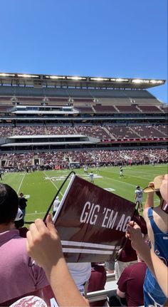 fans at a football game are holding up signs