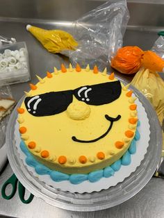 a cake with sunglasses on it sitting on a table next to plastic bags and other items