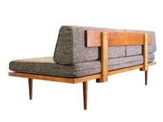 a couch that is sitting on top of a wooden frame and has a seat cushion