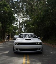 a white car is driving down the road