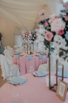 the tables are set up with pink and blue linens