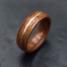 a wooden ring is shown on a black surface