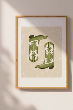 a pair of green cowboy boots hanging on a wall next to a potted plant