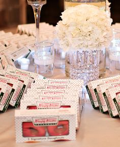 the table is set up with wine glasses and candy boxes